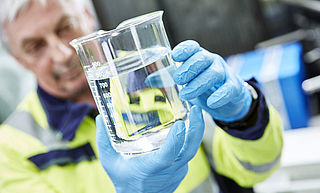 WESSLING employee examines water sample